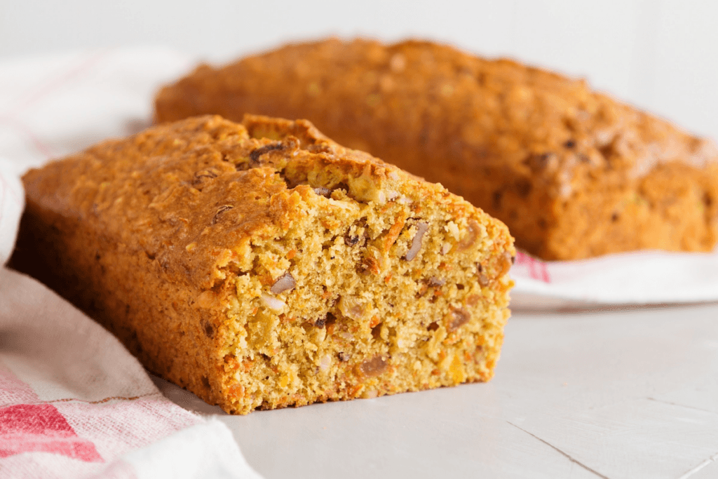 Bolo de cenoura com nozes em cima de uma mesa branca