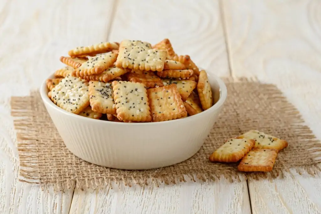 Recipiente com biscoitos de gergelim em cima de uma mesa de madeira