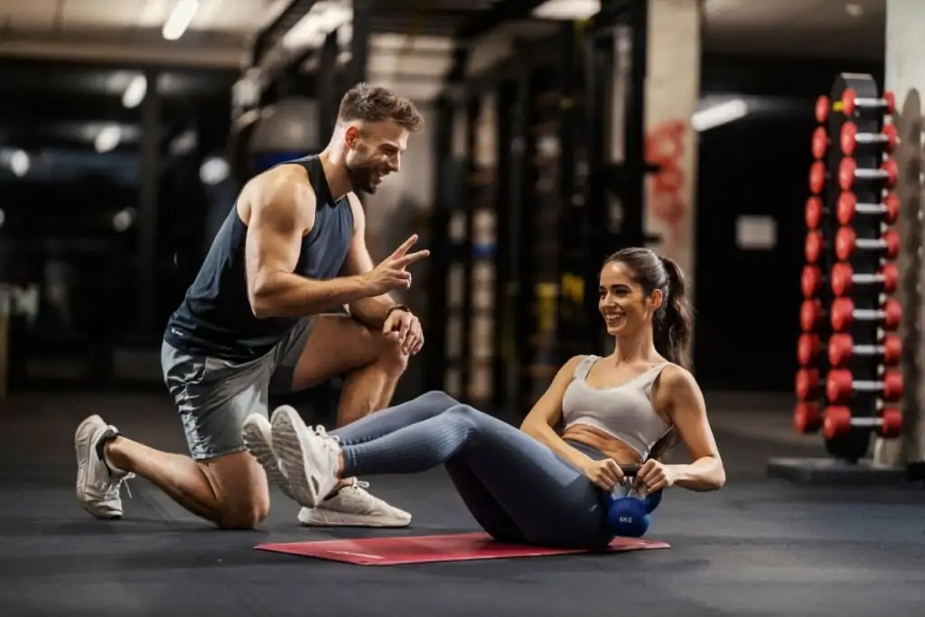 Personal trainer ajudando uma mulher na academia 