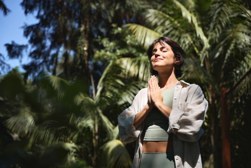 Mulher rezando em parque ao ar livre 