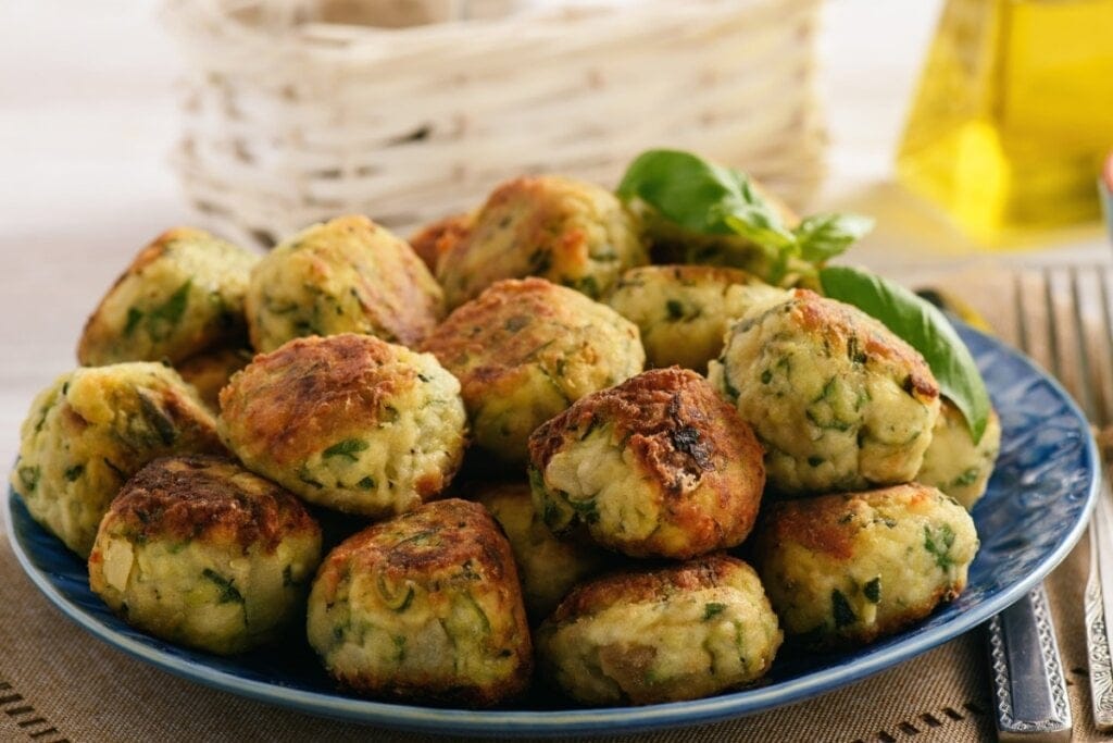 Bolinhos de grão-de-bico com salsinha empilhados em um prato azul