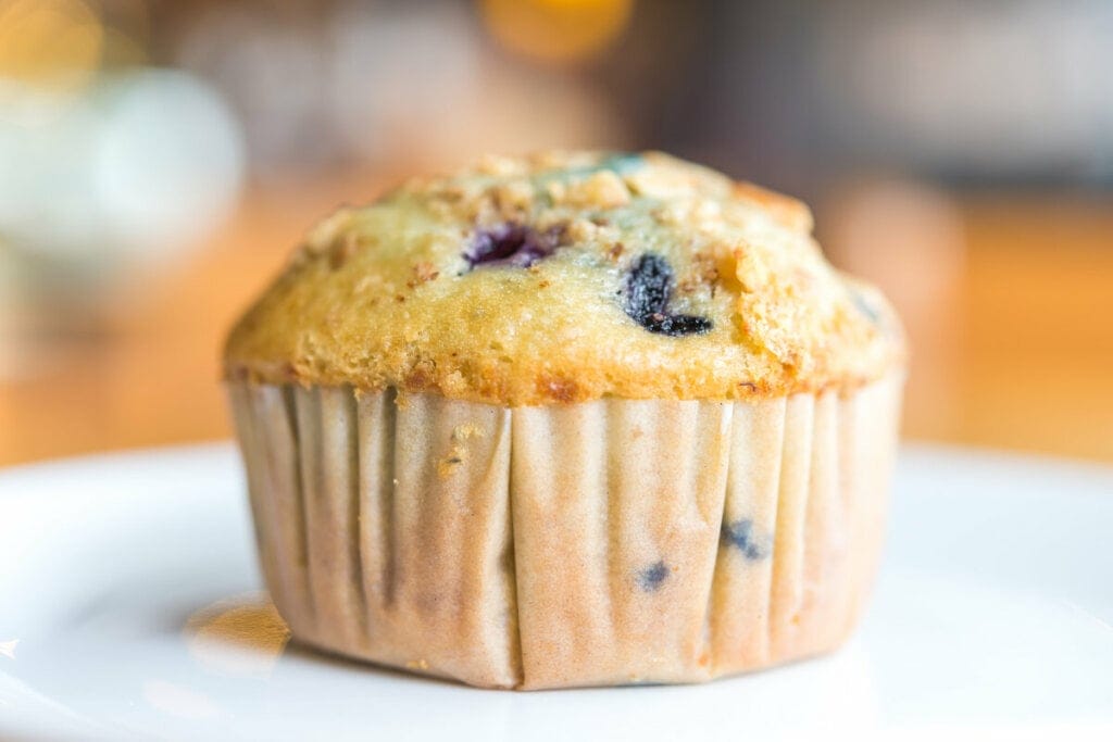 Muffin com uvas-passas em cima de uma mesa branca