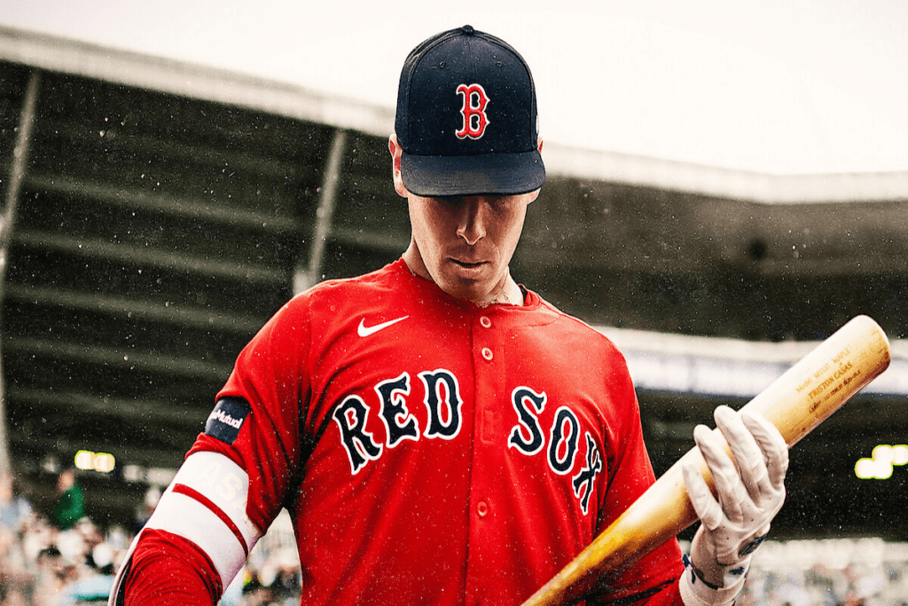 Imagem de um homem vestindo o uniforme do time de baseball Boston Red Sox com um boné preto e bastão de madeira na mão