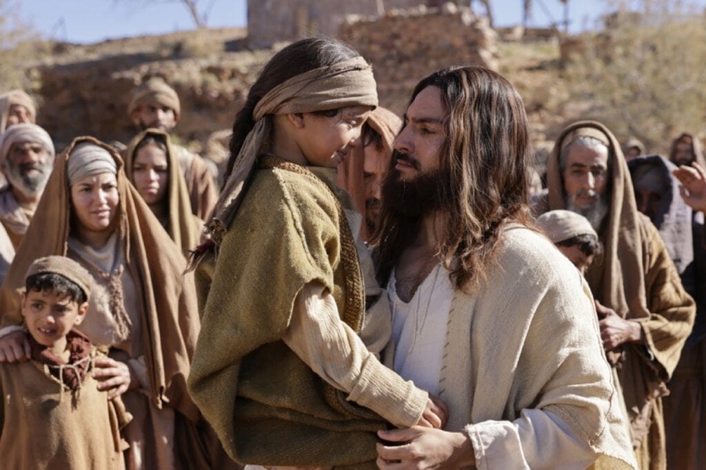 Jesus no filme"A última Ceia" segurando uma criança