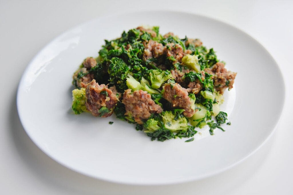 Prato branco com carne moída e brócolis