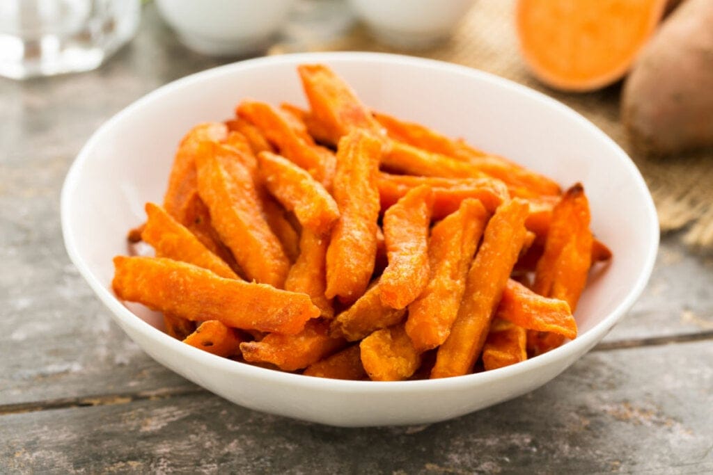 Batata-doce frita em palitos servida em um bowl branco