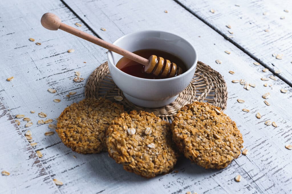 Biscoitos com chia em cima de uma mesa de madeira com mel