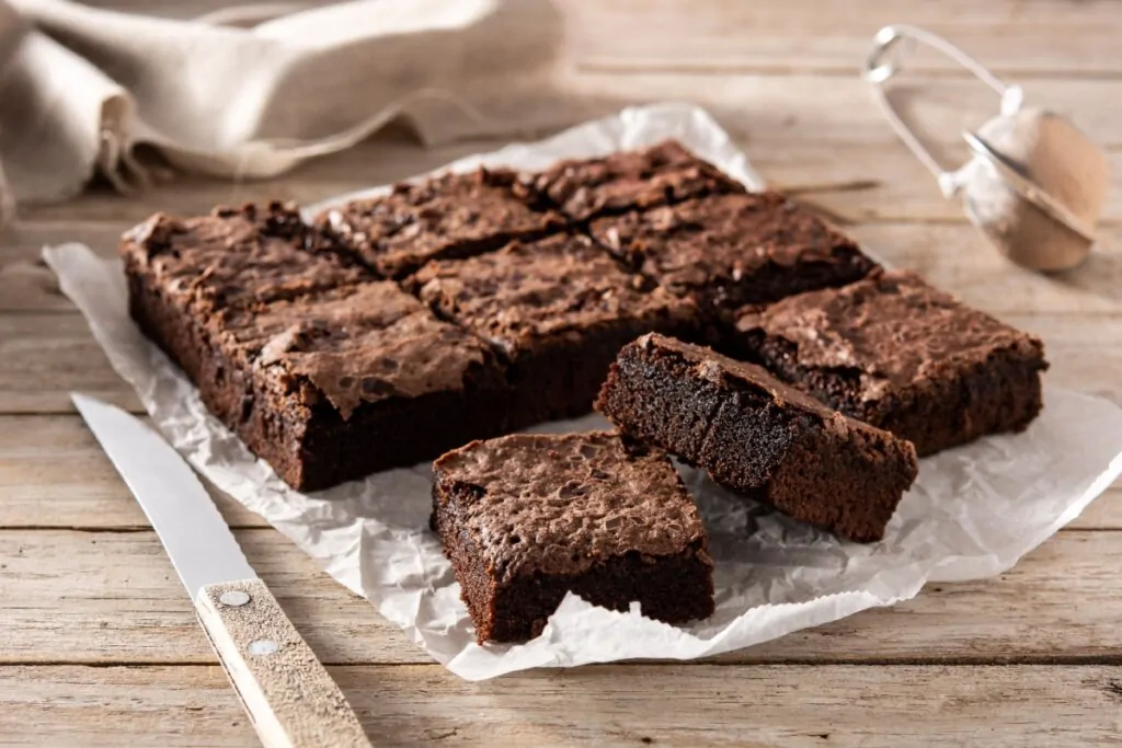 Brownie cortado em quadrados em cima de papel-manteiga