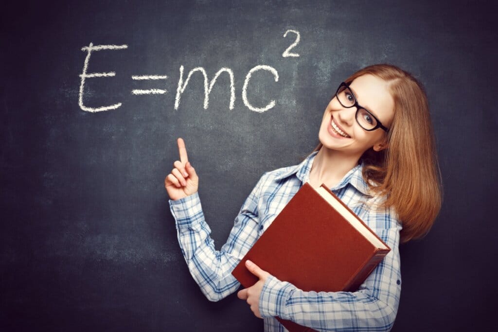 Jovem segurando livro e apontando para fórmula matemática escrita em lousa