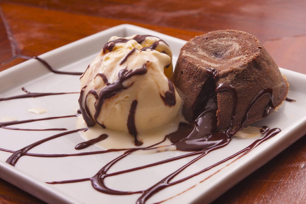 Petit gateau com sorvete de creme e calda de chocolate em um prato branco