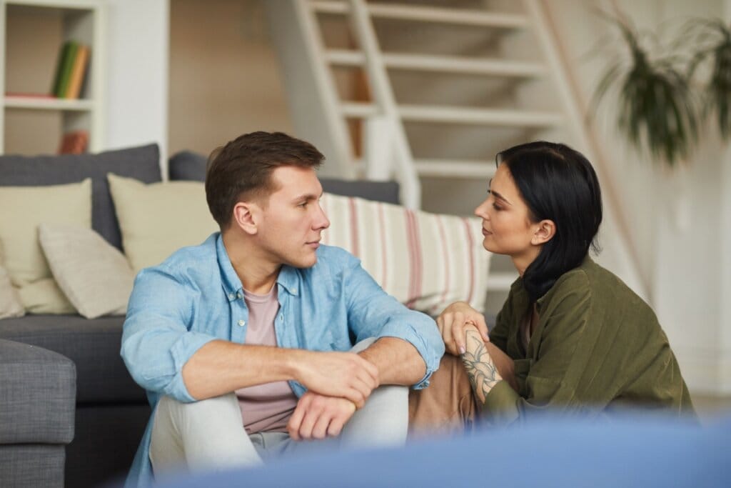 Homem e mulher conversando perto de sofá