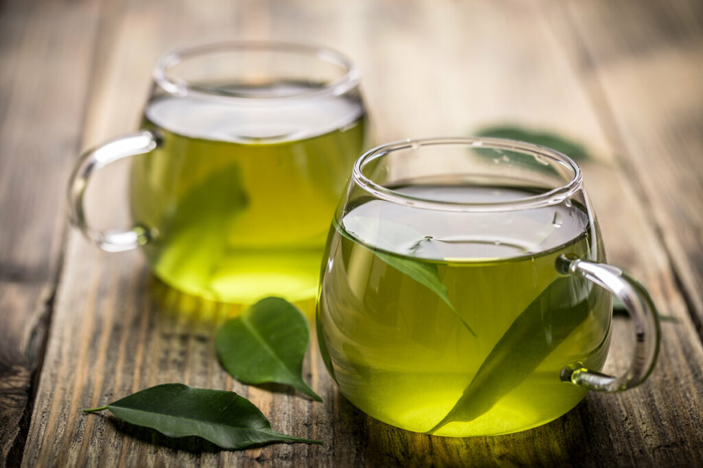 Chá verde em uma xícara transparente