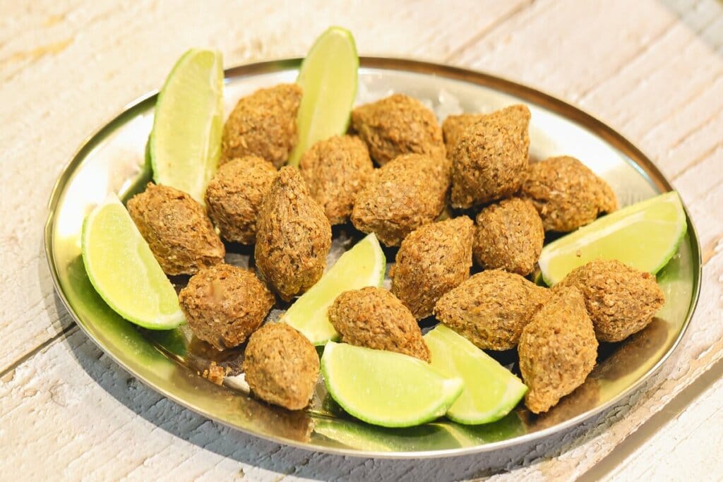 Miniquibes em um recipiente de prata com pedaços de limão