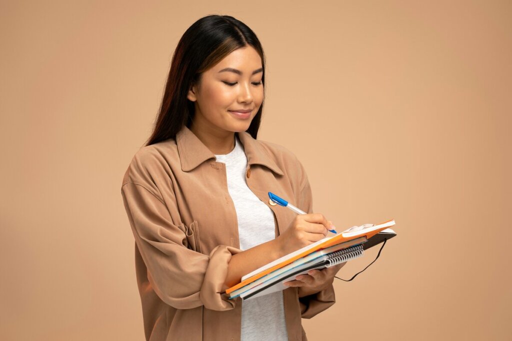 Menina sorrindo escrevendo em um caderno