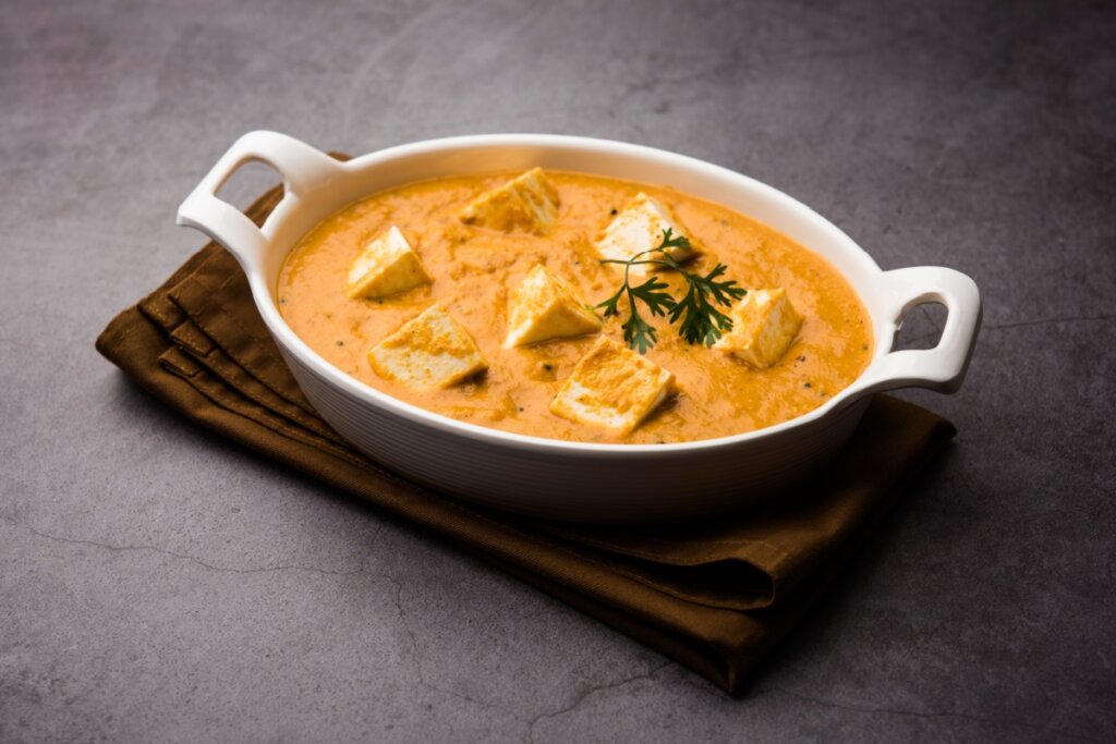 Recipiente branco com tofu ao curry com leite de coco