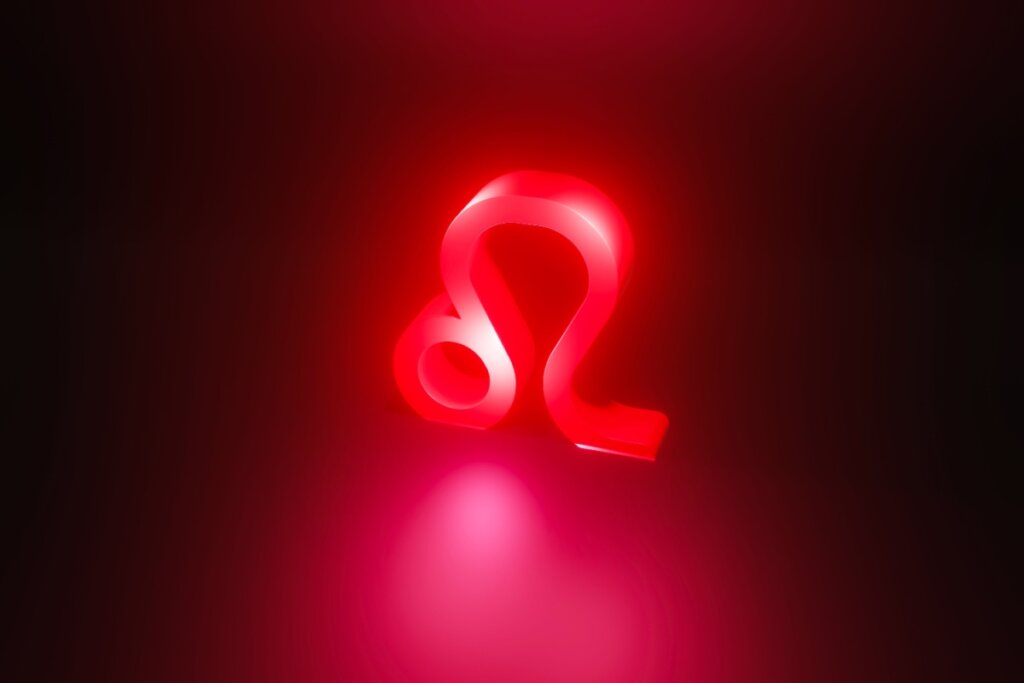 Ilustração em vermelho do símbolo do signo de Leão em fundo vermelho escuro