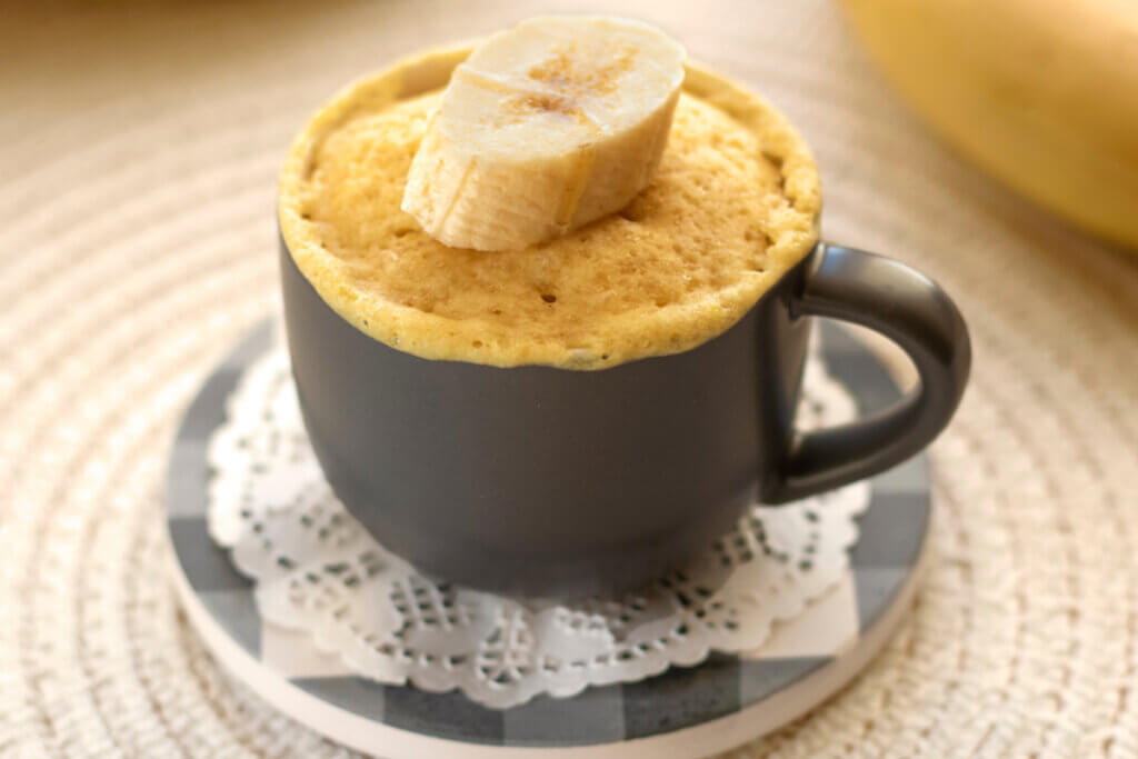 Bolo em uma caneca cinza decorado com um pedaço de banana