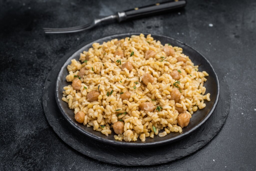 Arroz integral com grão-de-bico  em um prato preto 