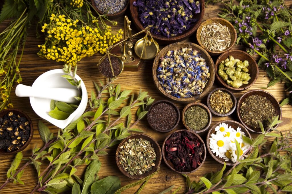 Ervas para banho espalhadas em uma mesa de madeira