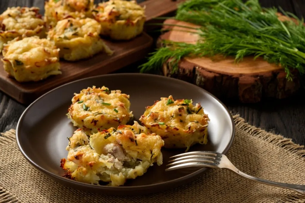 Três muffins de batata-doce com frango em cima de um prato marrom 