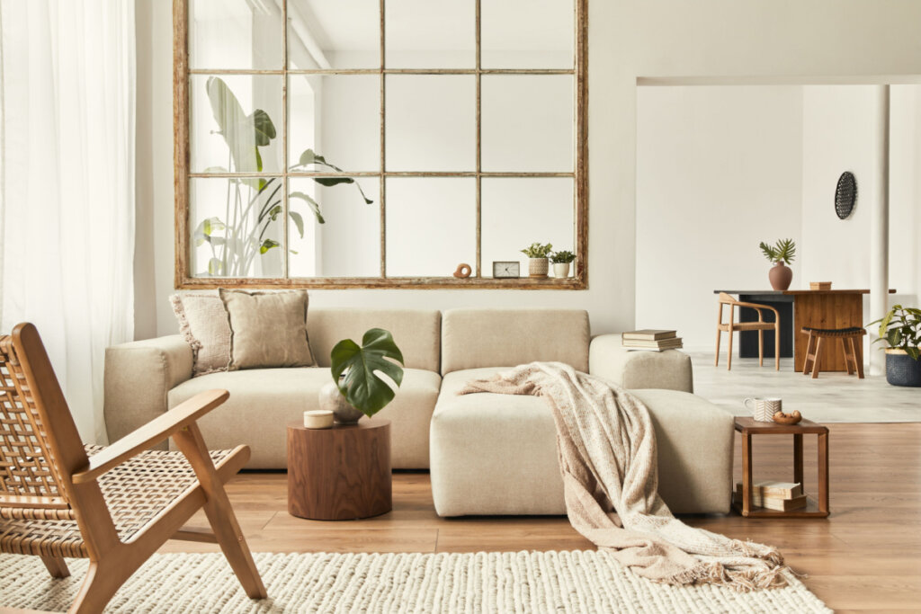 foto de uma sala de estar com decoração moderna e aconchegante, com sofá claro, móveis de madeira e plantas.