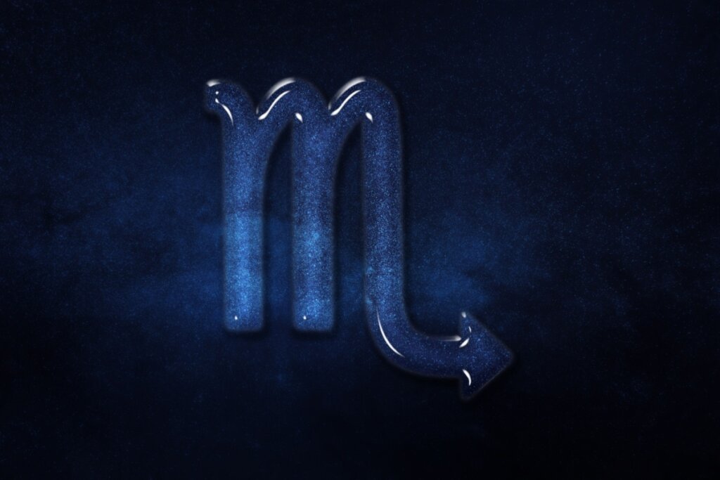 Representação visual do signo de Escorpião, mostrando a letra "M" com uma ponta em forma de flecha (ferrão) com aparência de cristal azul cintilante, sobre um fundo de céu noturno azul-escuro profundo e estrelado.