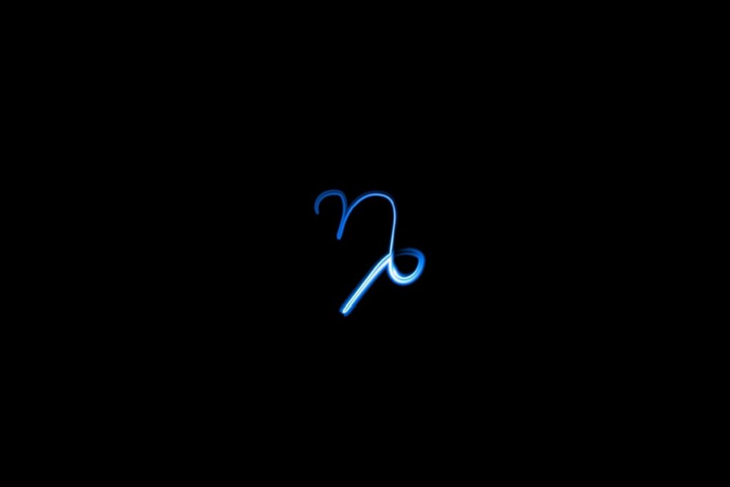 Ilustração do signo de capricórnio em azul sobre um fundo preto