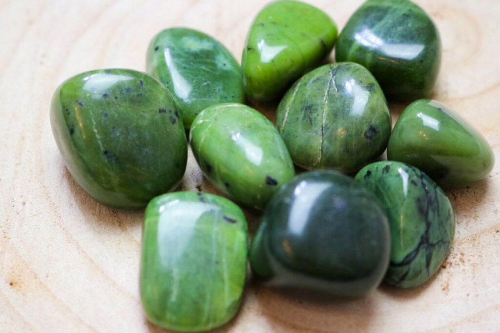 Pedras de Jade verdes em uma superfície bege 