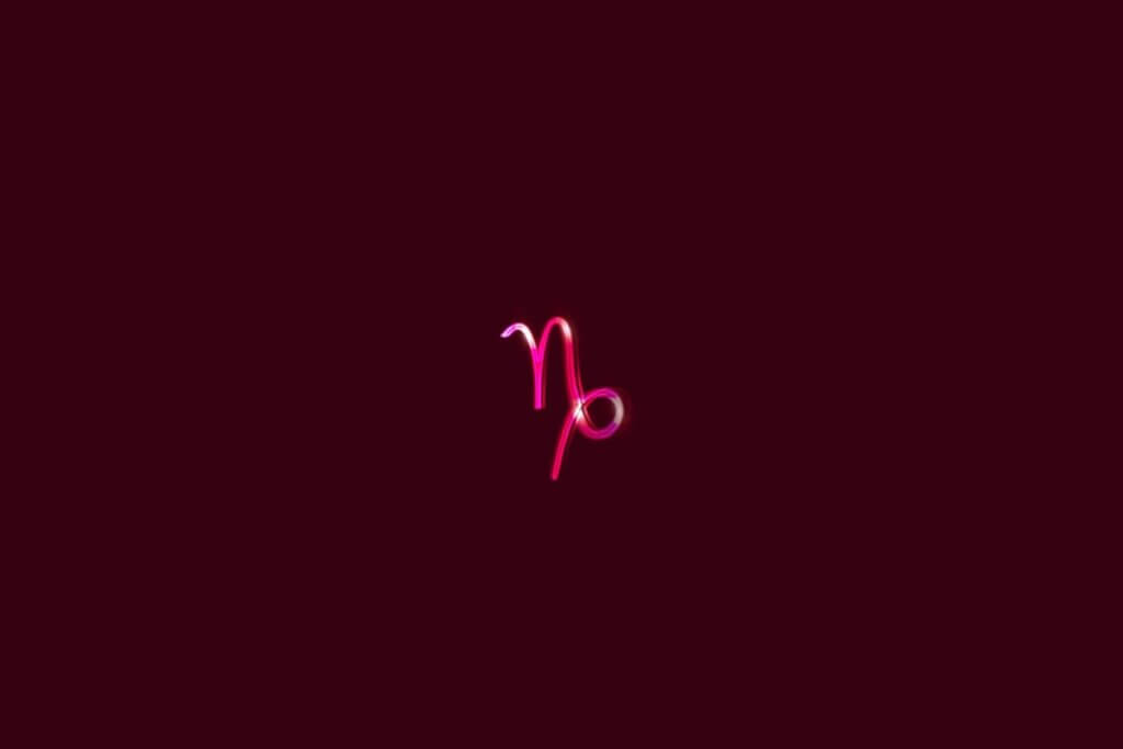 Ilustração do signo de Capricórnio rosa em um fundo vermelho