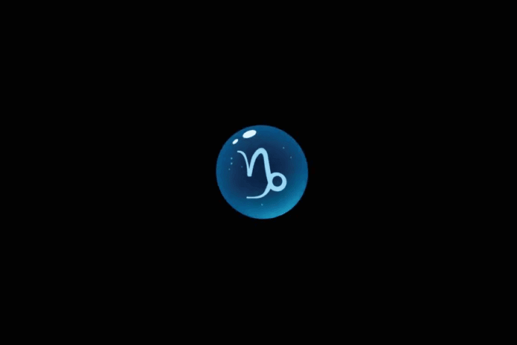 Imagem com fundo preto, apresentando uma esfera azul brilhante no centro, com o símbolo astrológico do signo de Capricórnio em azul-claro, formado por linhas curvas e uma pequena volta circular na extremidade. A esfera possui efeito tridimensional, pequenos pontos luminosos e reflexos brancos na parte superior.